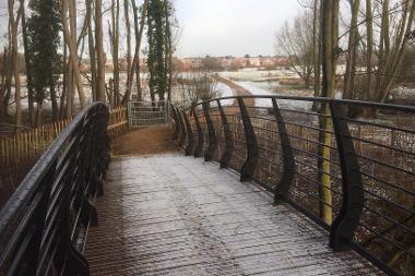 View across Colney River Crossing in winter with dusting of snow on the ground.
