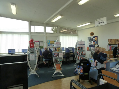 Internal view of Wroxham Library with computer terminals and part of the issue desk.