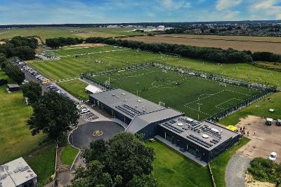 Aerial view of The Nest with pitches in use, looking East towards the airport.