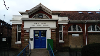 Exterior photograph of Mile Cross Library showing the ramp to the entrance and bike racks on the library wall.