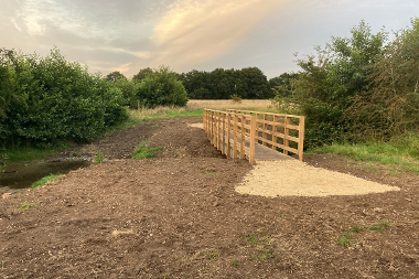 A newly constructed wooden footbridge over an open ditch at East Wymondham.