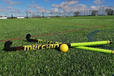 Crossed hockey sticks and a ball lying on the 3G pitch at Aylsham Sports Hub.