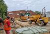 Groundwork for the building works with an excavator and dump truck on site. 