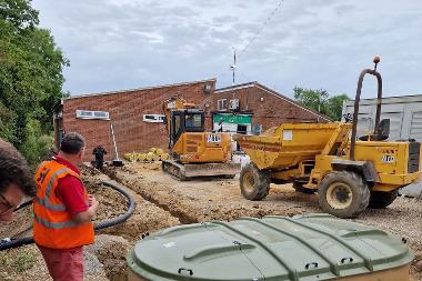 Groundwork for the building works with an excavator and dump truck on site. 