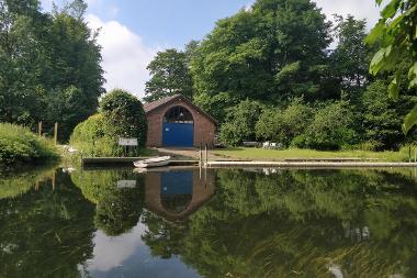 Photograph across the River Yare looking at the Yare Boat Club's original boathouse.