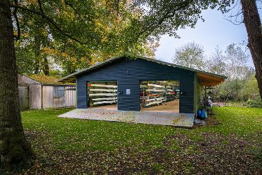 Photograph of the new boat house with the doors open, showing the boats stored inside. (Photo by Fisheye)