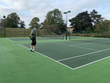 A man preparing to receive a serve on a tennis court.