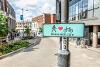 A photograph of a 'Share with Care' sign - featuring a human figure, a heart symbol, and a bicycle - mounted on a lamppost along Westlegate.