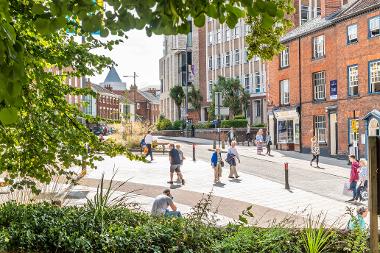 A photograph taken from the All Saints Church side, capturing the newly pedestrianised Westlegate and All Saints Green.