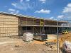 An image of the Aylsham Gym & Fitness Hub being built. The image shows a construction site with scaffolding around the building and various materials laid out on the ground.