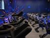 The image shows spin bikes lined up inside the new fitness studio, with disco lights lighting up the room.