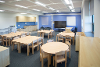 An image of a classroom at Blofield Primary School. The image shows circular and rectangular tables with a whiteboard board and storage space.
